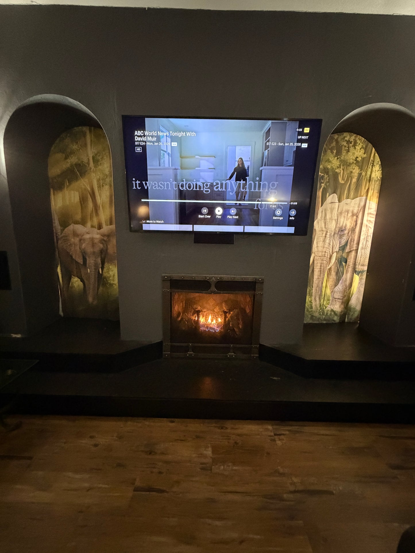 Tall thin TV screen displaying a message in a dark room with decorative elements.