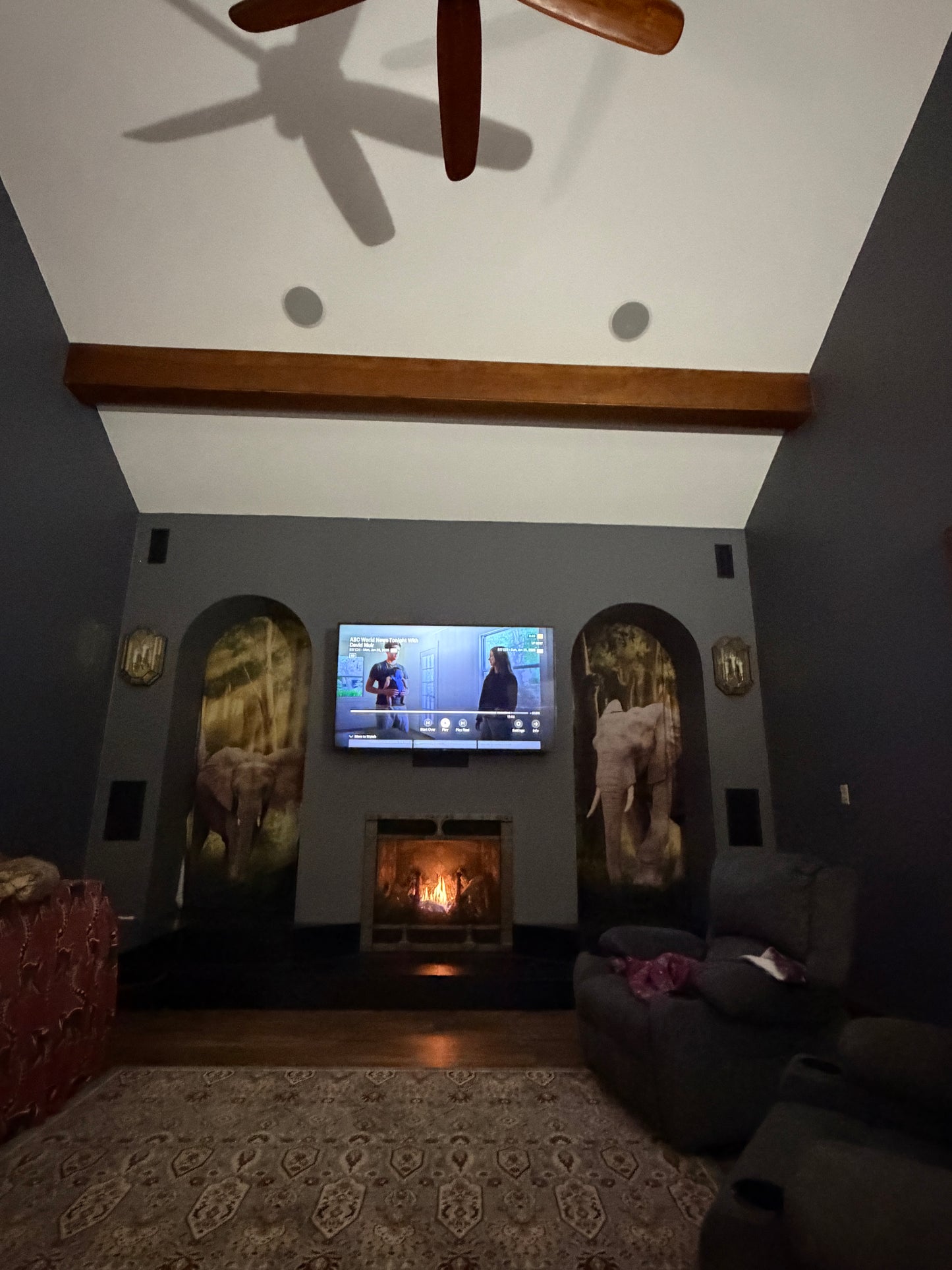 Living room with a TV on a stand, surrounded by furniture and decor.