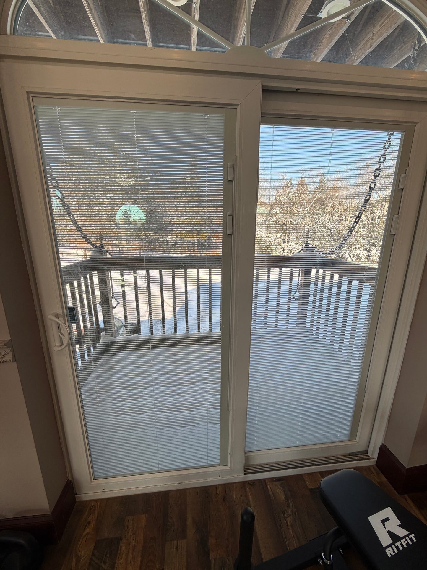Looking out library window across draw bridge deck with chains with blinds inside glass showing outdoor view