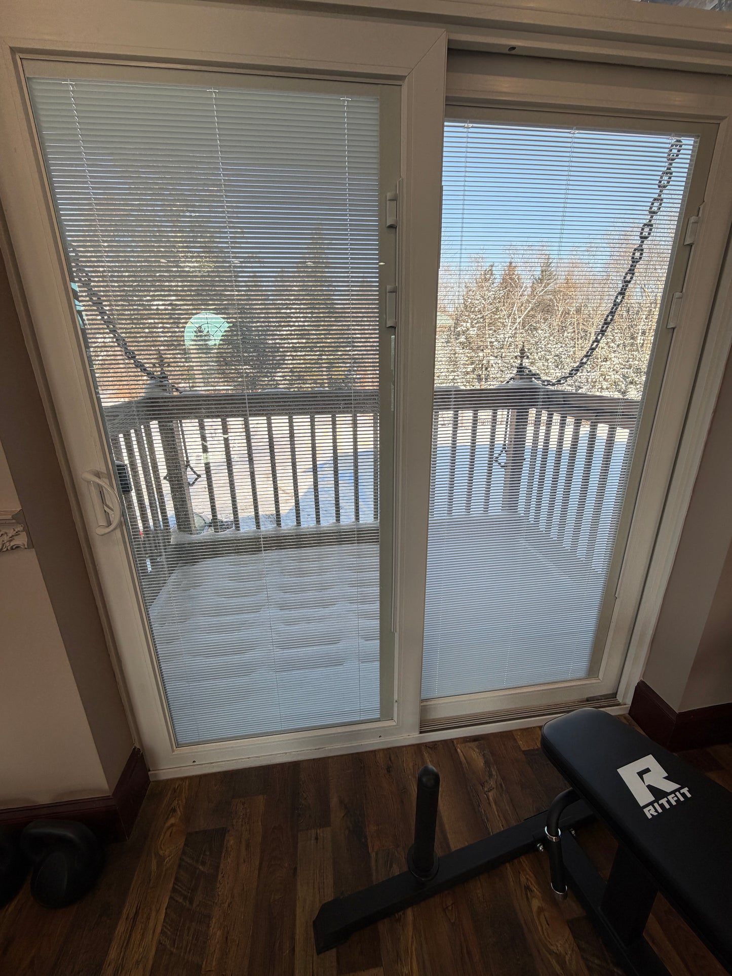 Drawbridge deck with sliding glass door with blinds partially open, showing outdoor view