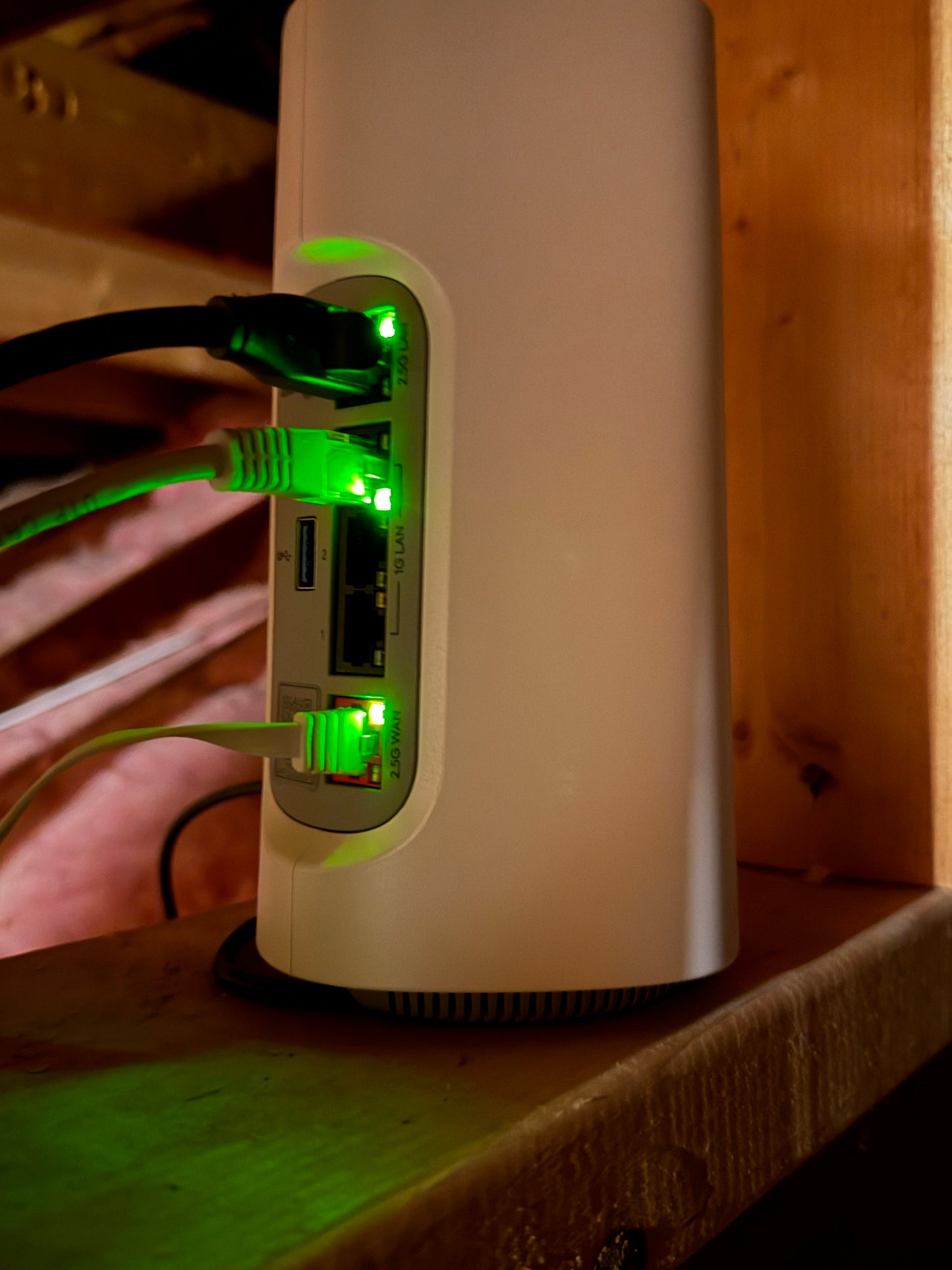 Fiber optics network router with Ethernet cables plugged in on a wooden surface