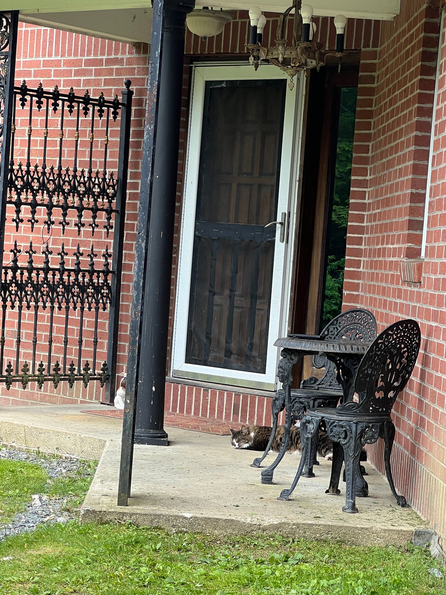 Black metal wrought iron  chairs  and gate  front of a brick building