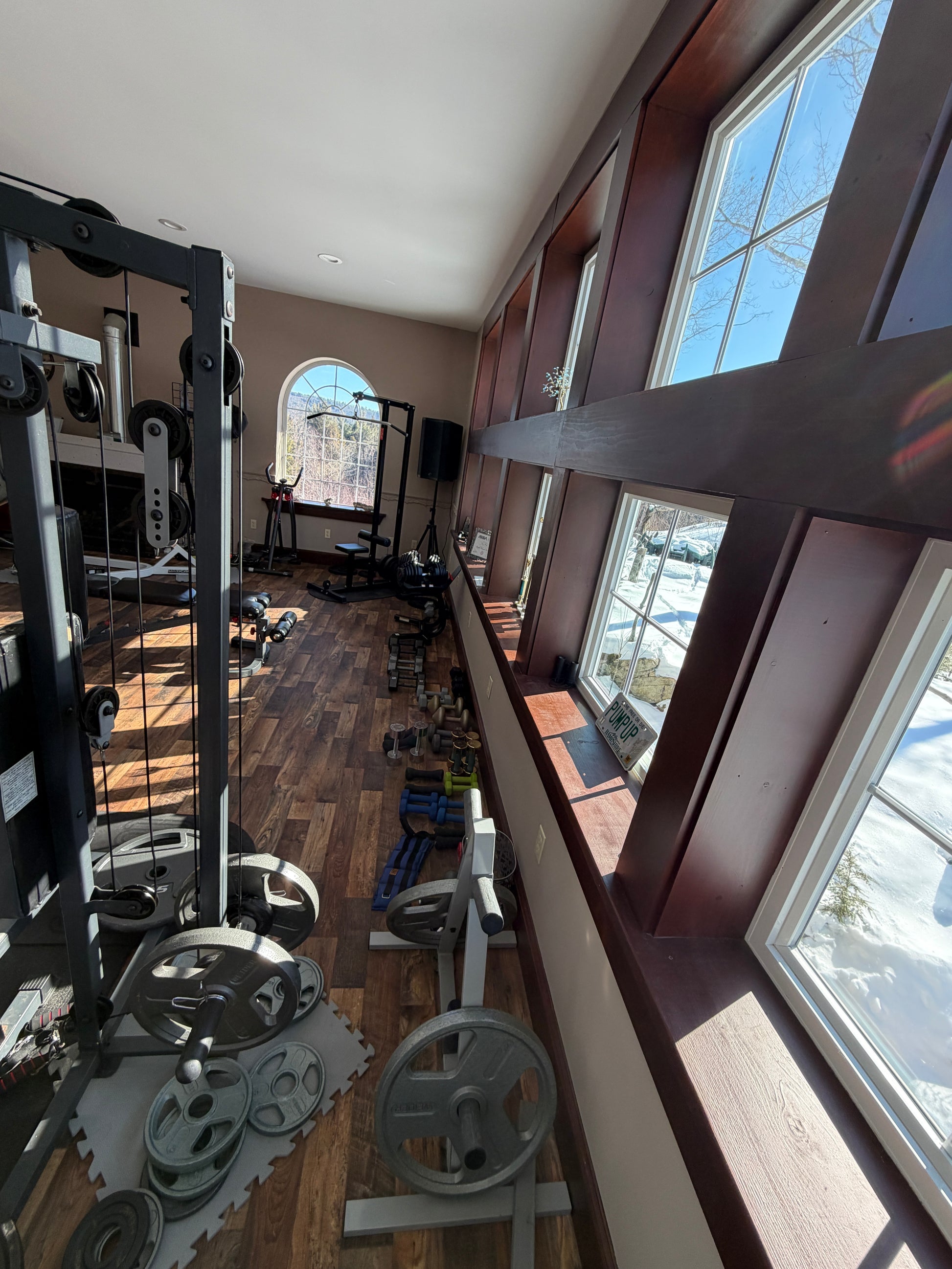 Gym interior with weightlifting equipment and large windows Nature View NH Estate