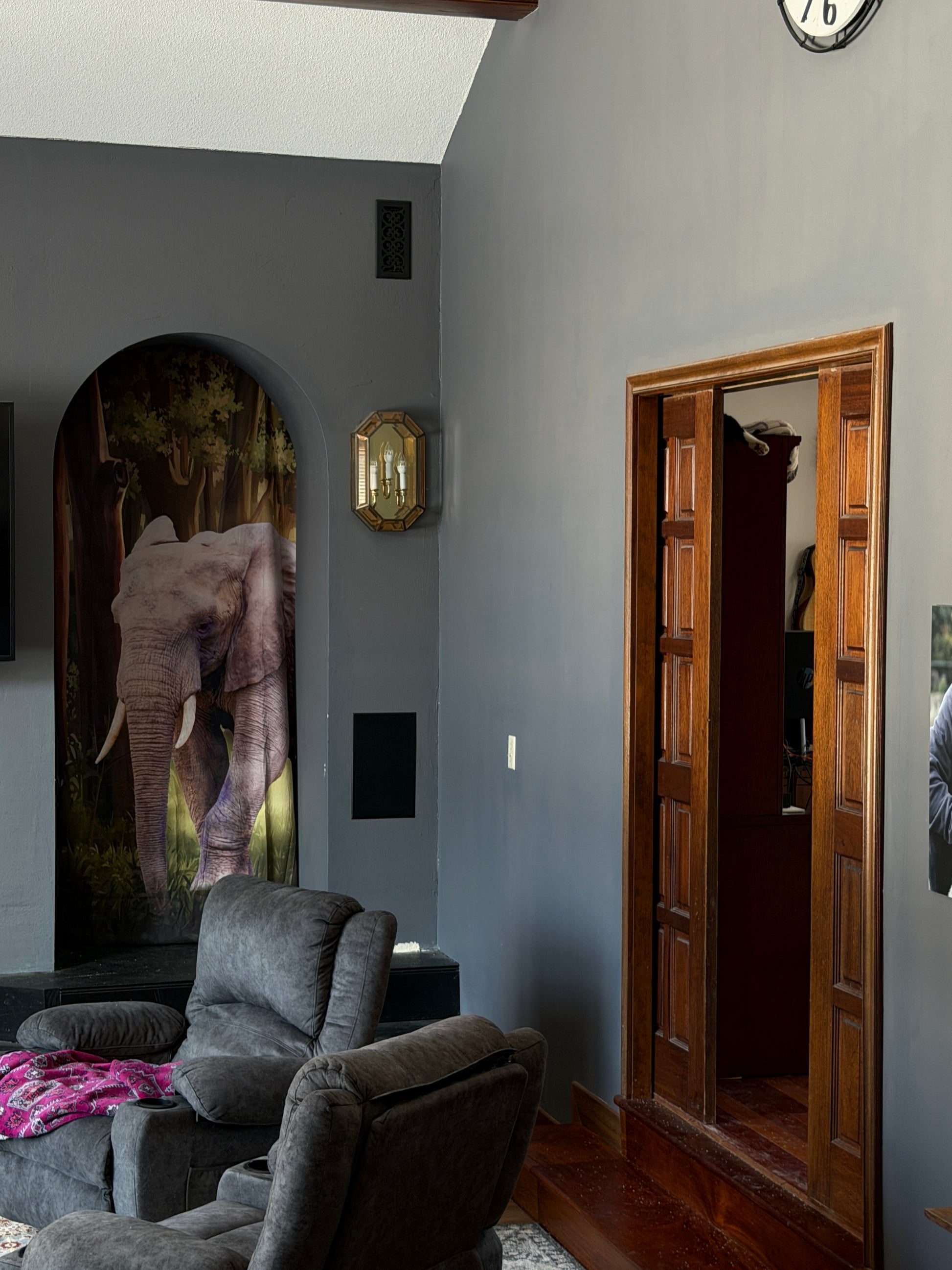 Ceiling with a wooden panel and decorative elements in a room.