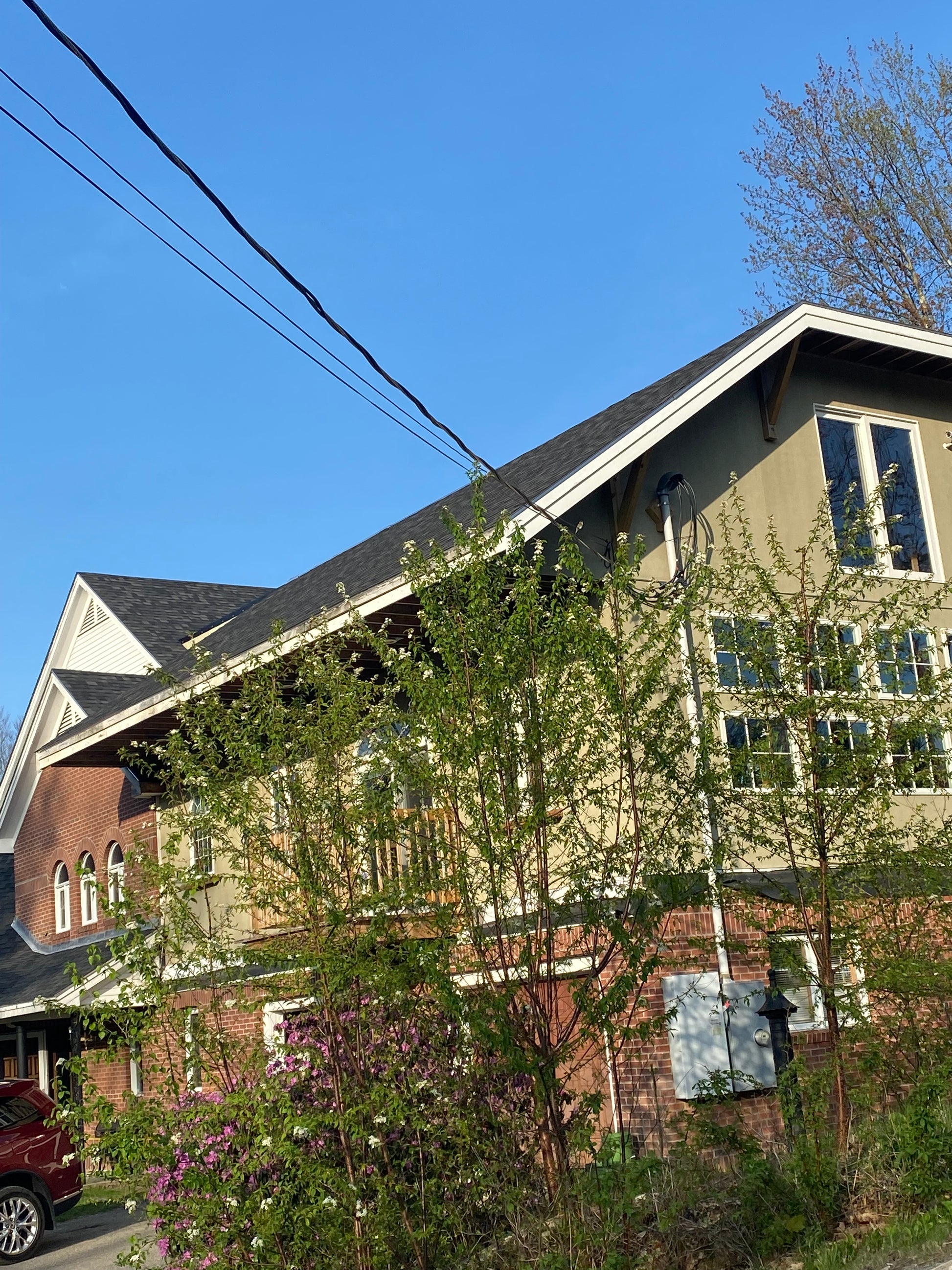 Top-down view of a building with greenery on the roof against a blue sky.