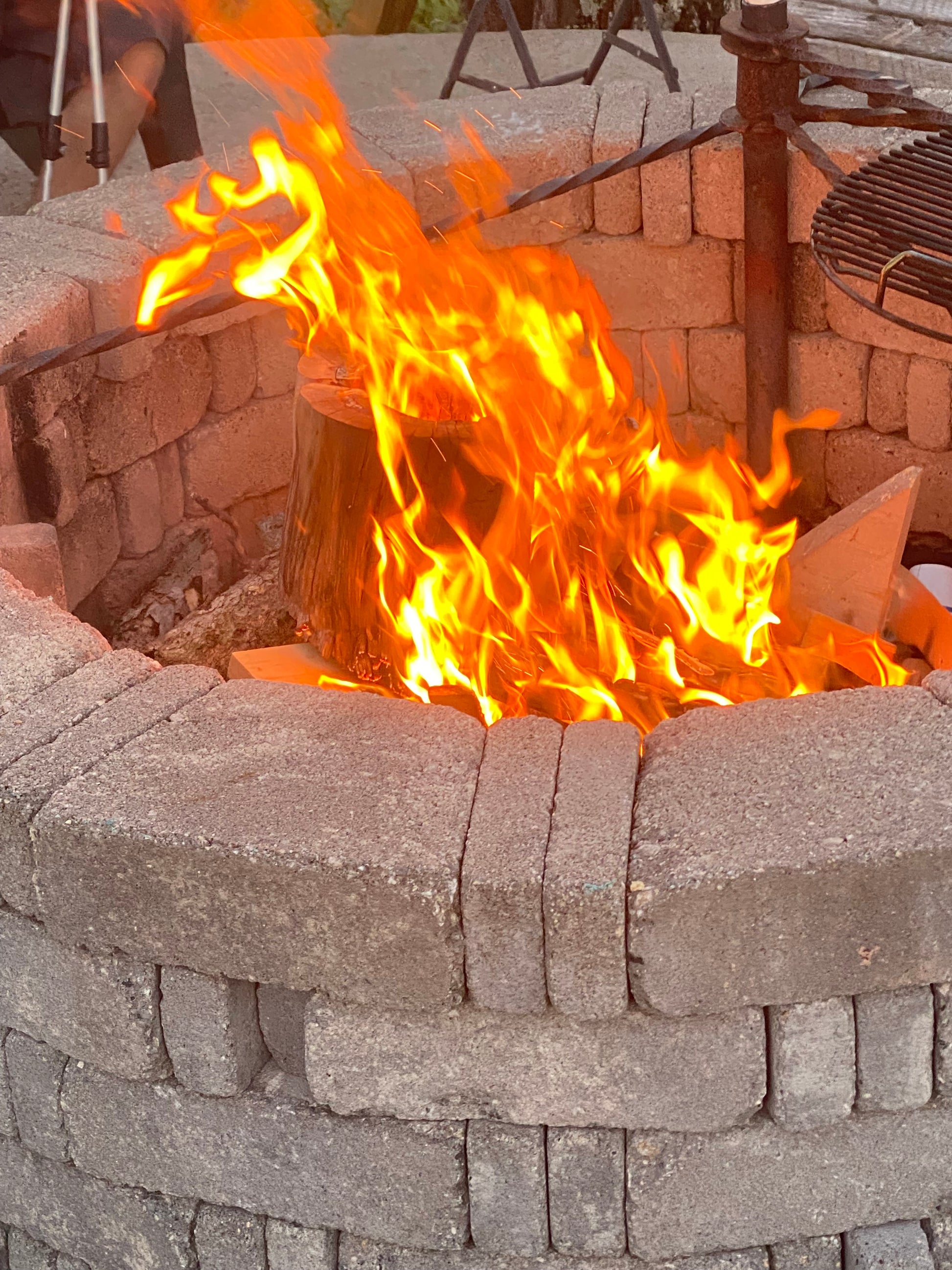 Fire burning inside a stone oven with bricks around it
