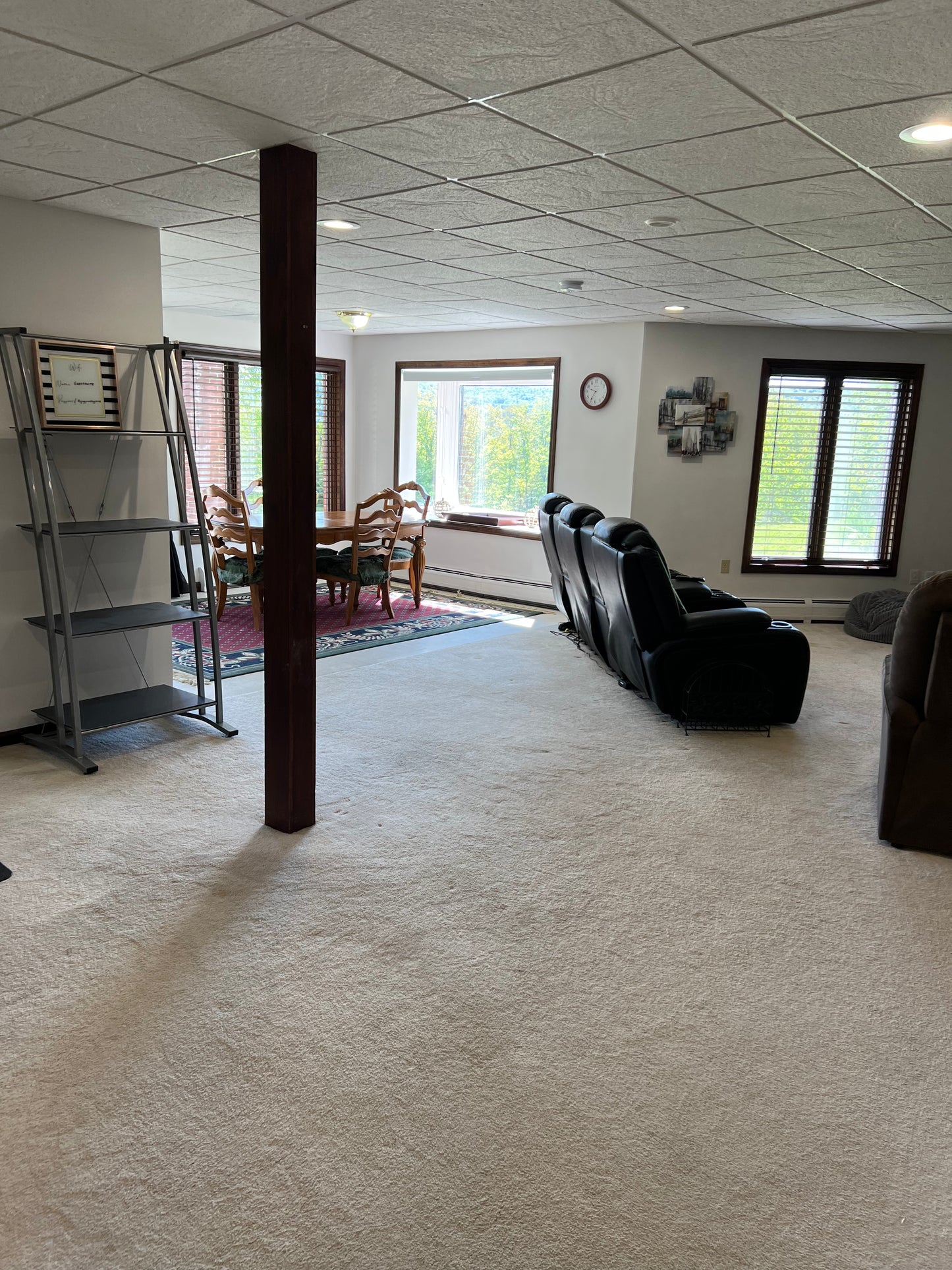Living room with recliner chairs, bookshelf, and dining area in the background Nature View NH Estate