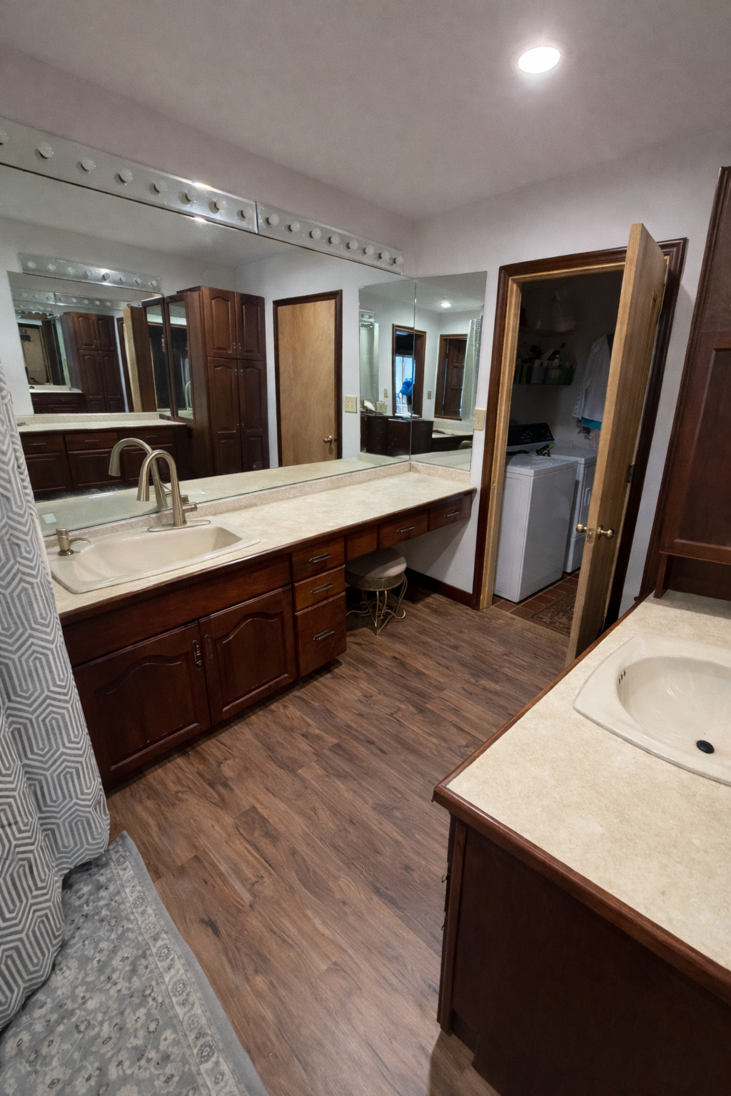 Bathroom interior with wooden vanity, sink, and mirror.