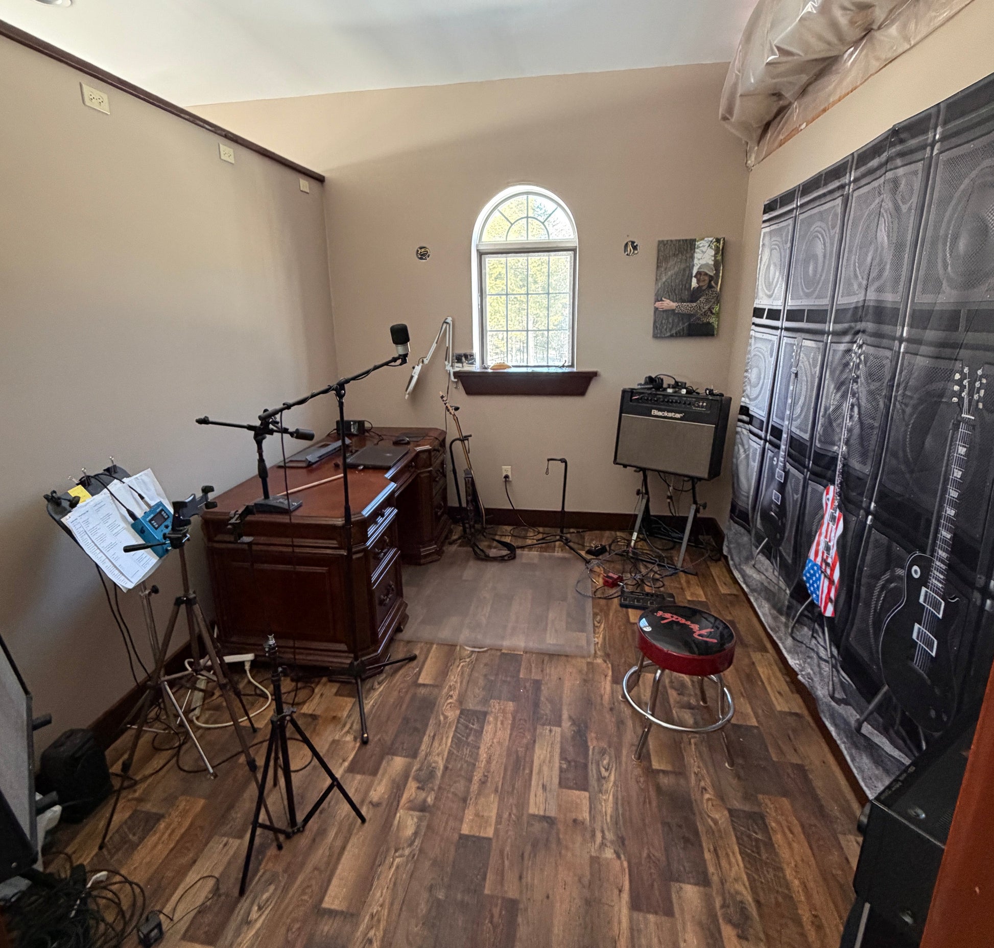Music room interior with wooden floor, white walls, and various music equipment.