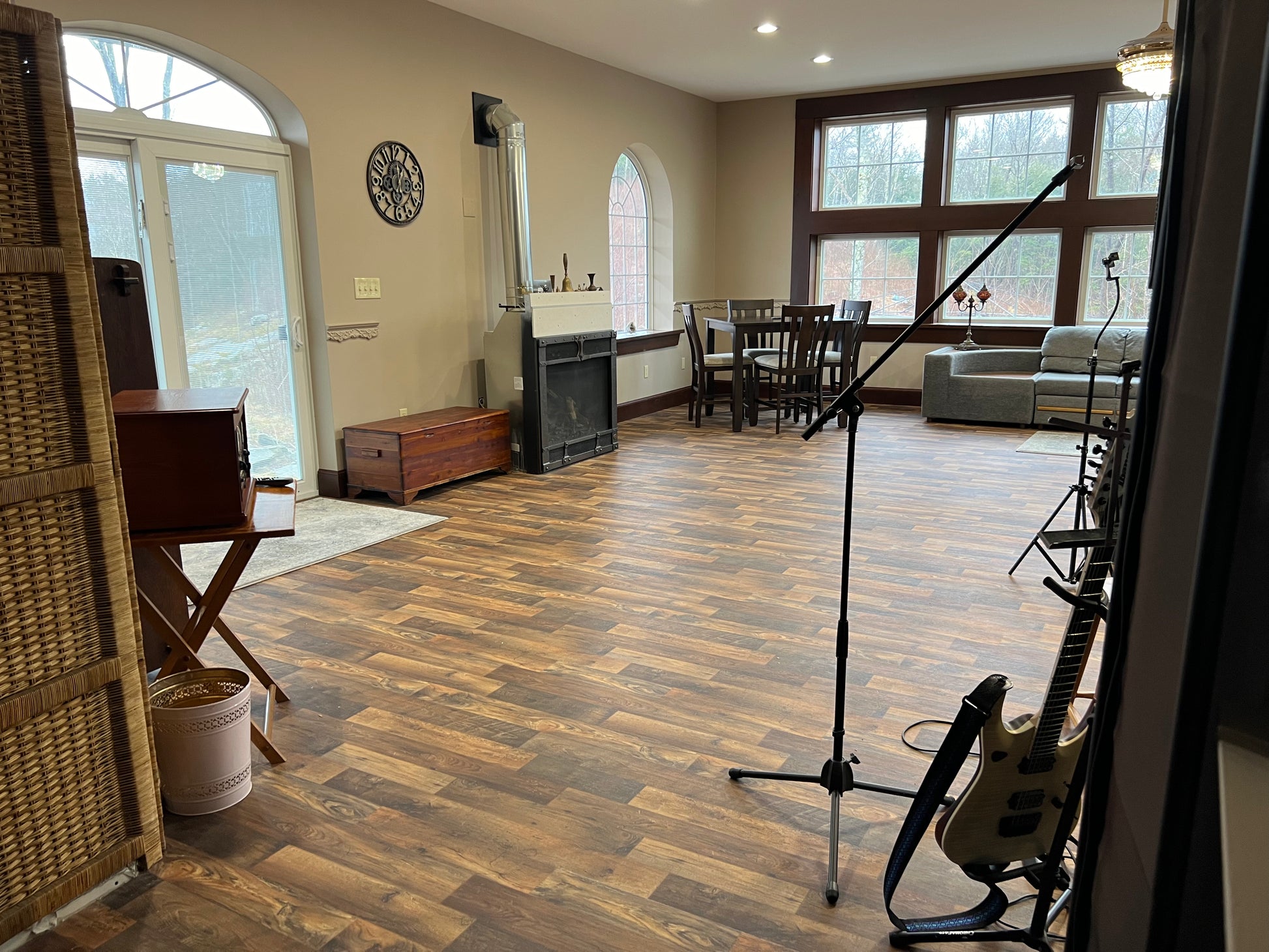Music practice room with guitar, microphone stand, and wooden flooring