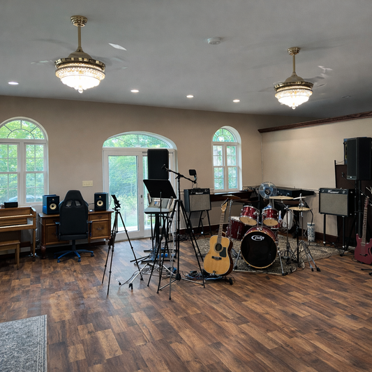 Music practice room with instruments and equipment on a wooden floor.