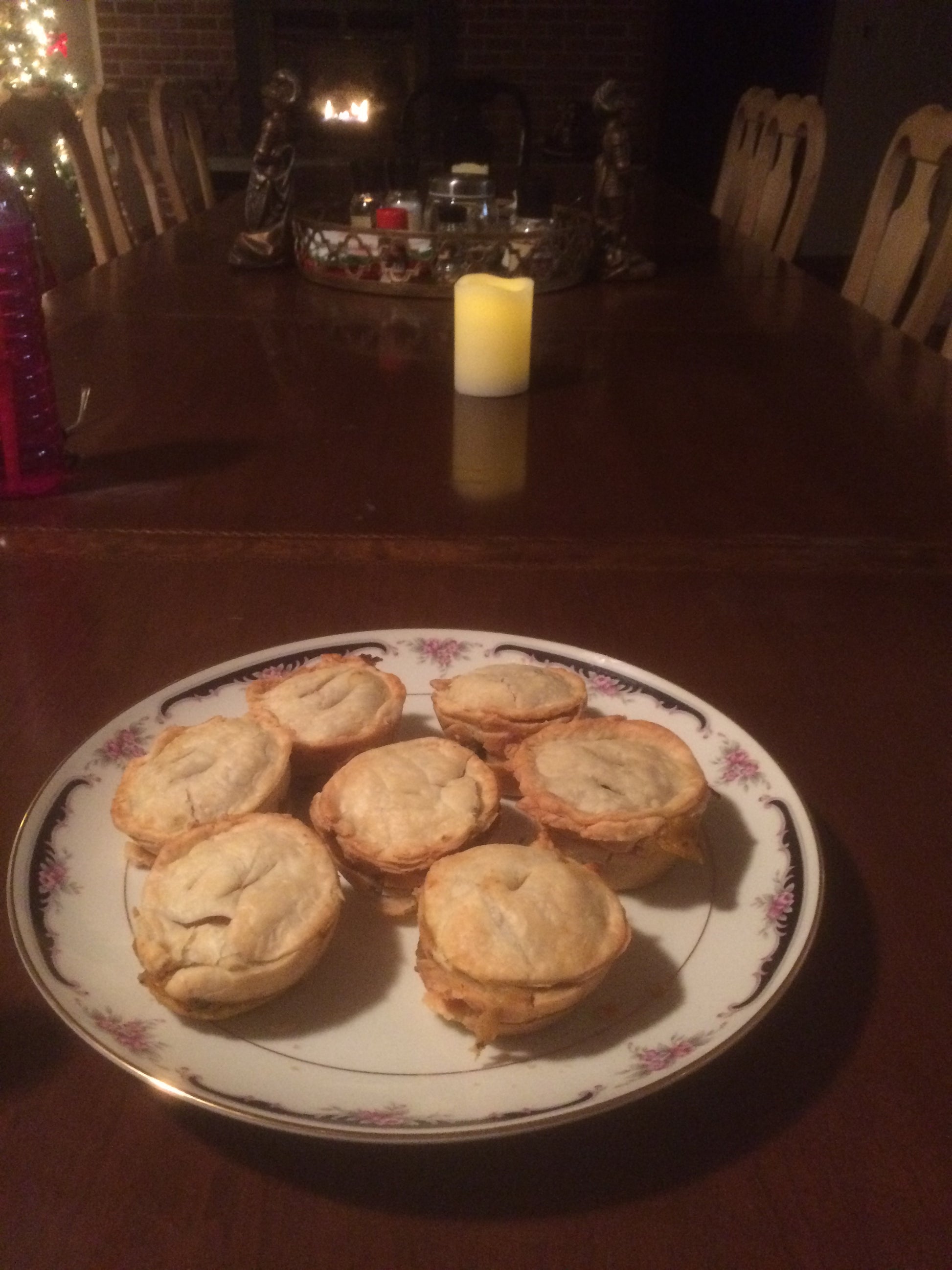 Plate of pies on a  dining room table with a fireplace in the background