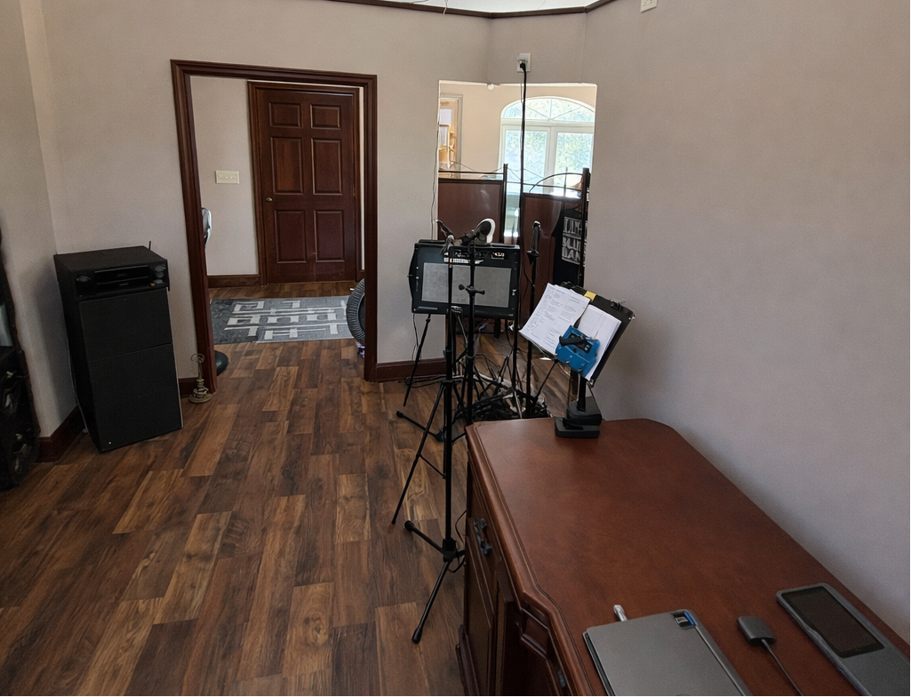 Room with wooden floor, desk, and musical equipment