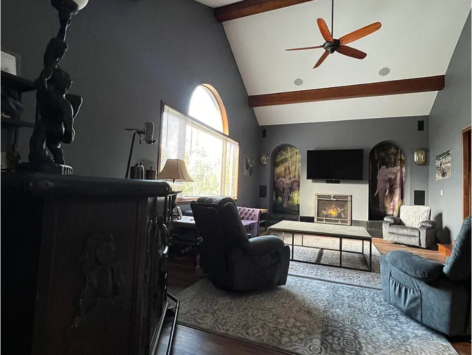 Living room with gray walls, a fireplace, and a television.
