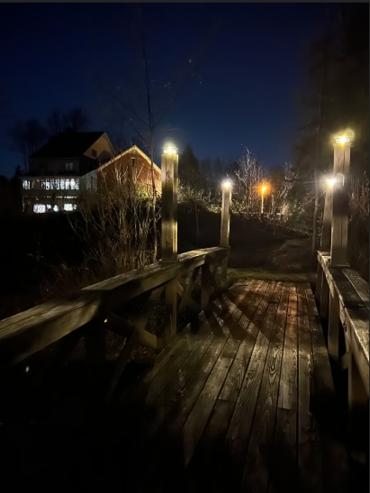 Wooden bridge  at night with lights illuminating the area Nature View NH Estate.
