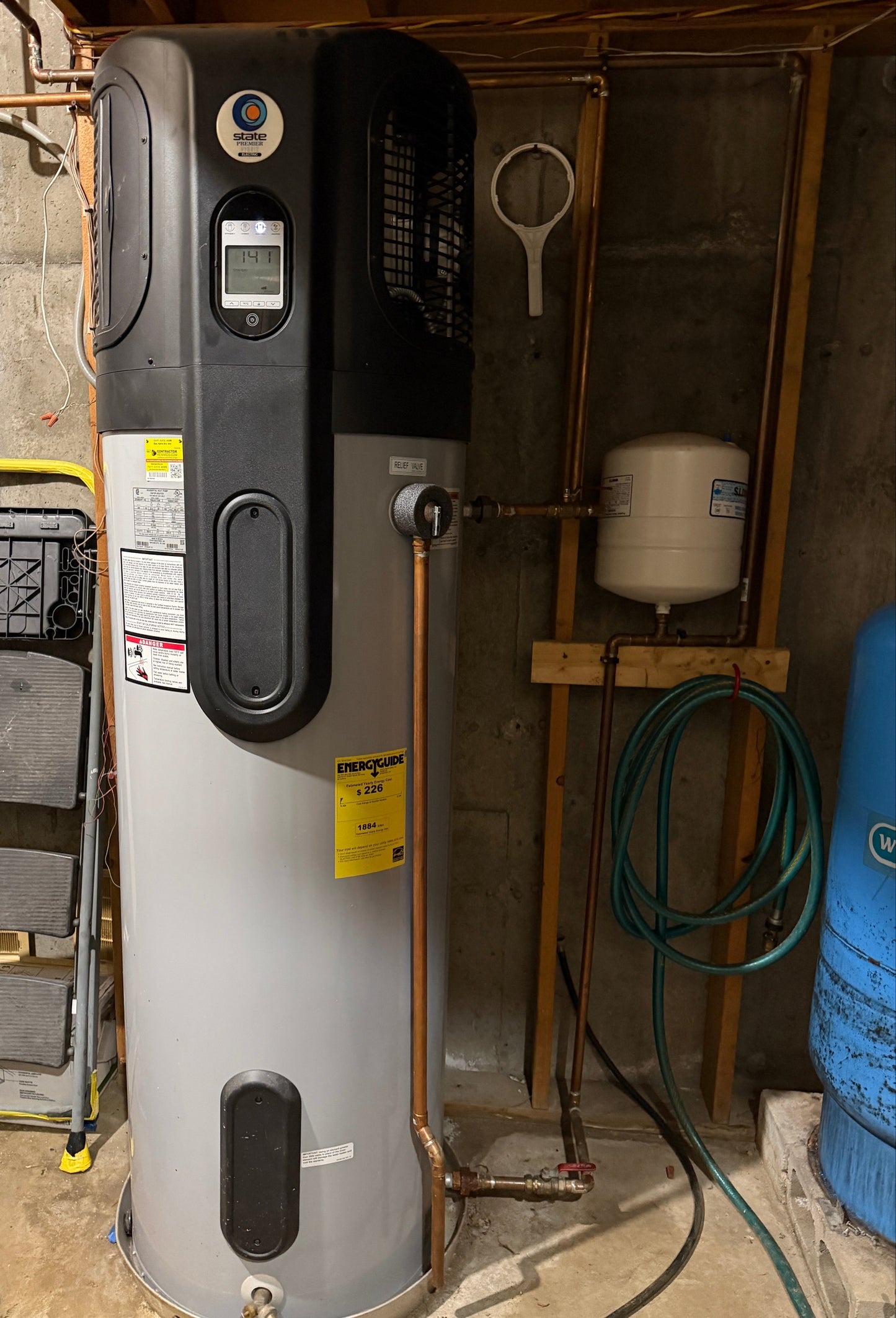 Hot water heater with various pipes and tools in the background.