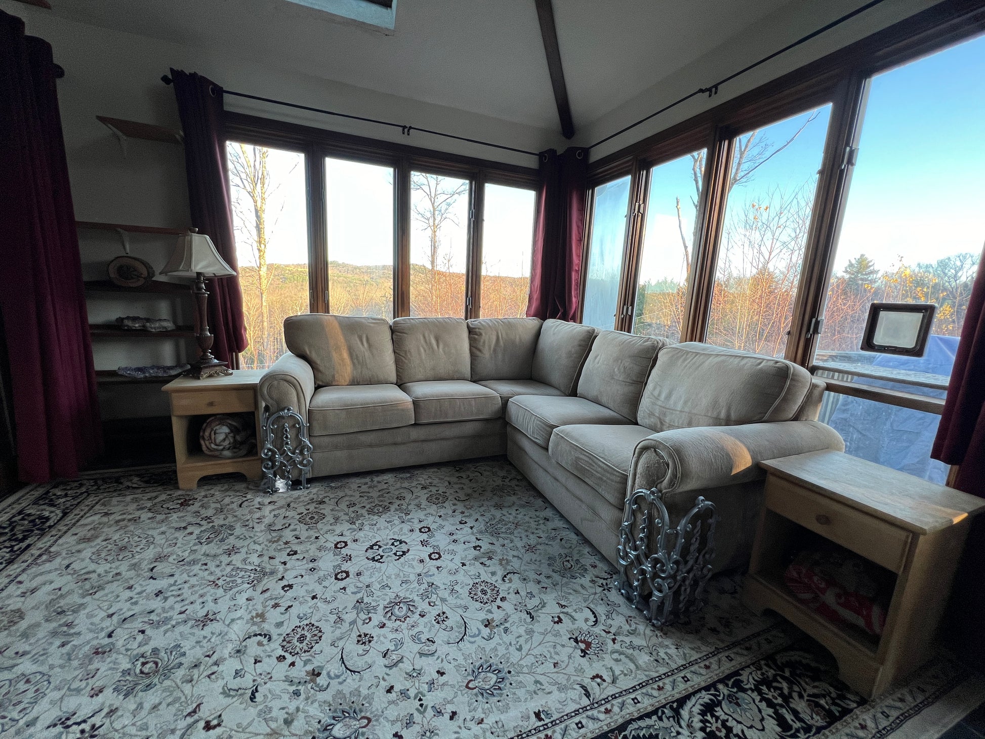 Living room with a sectional sofa, rug, and large windows.