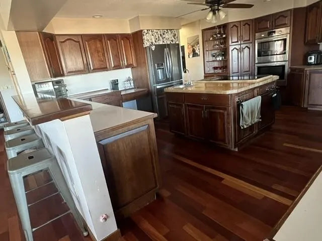 Modern kitchen with wooden cabinets, stainless steel appliances, and a island.