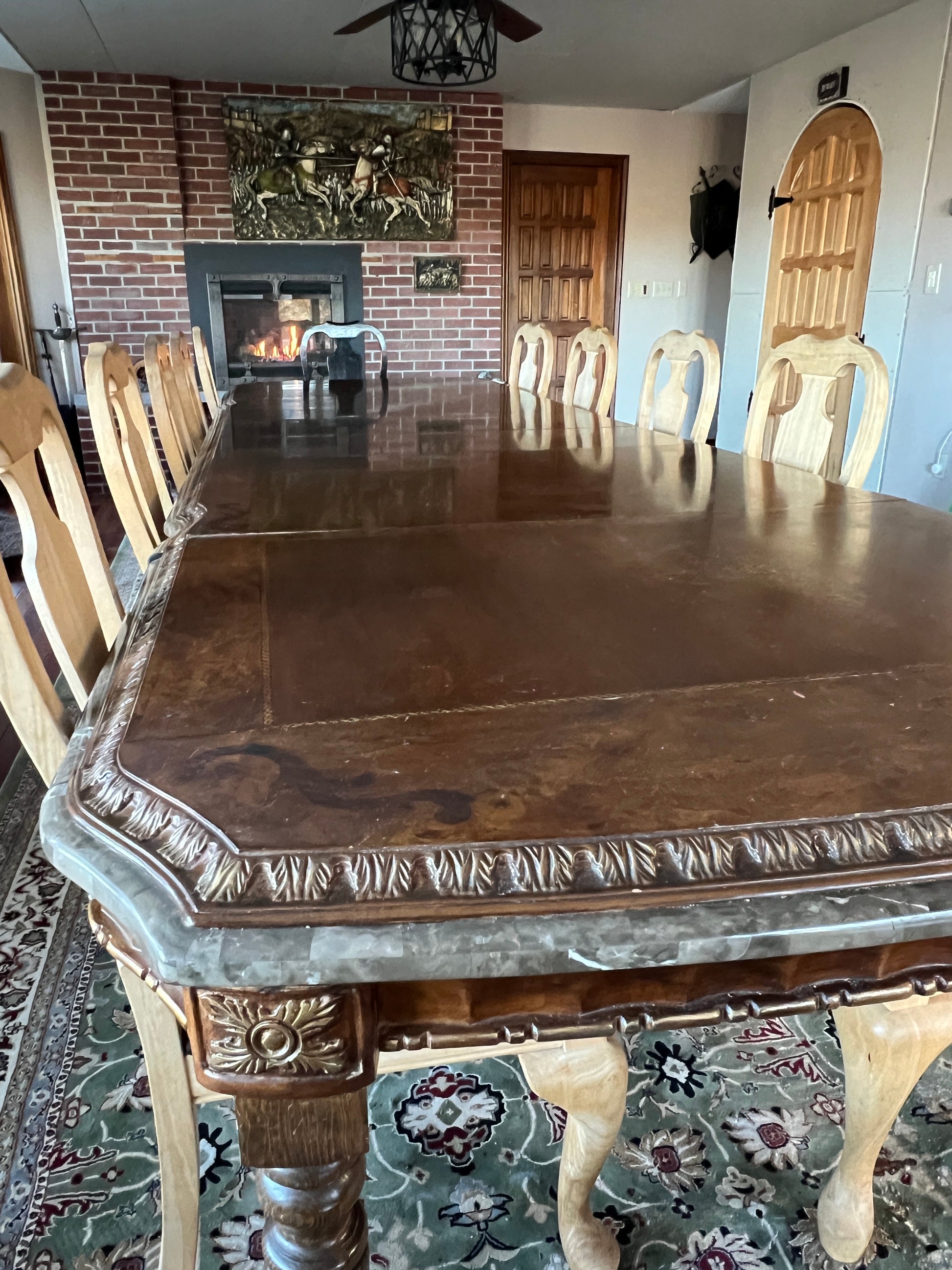 Wooden table with intricate carvings in a room with patterned rug and decorative elements mahogany doors .