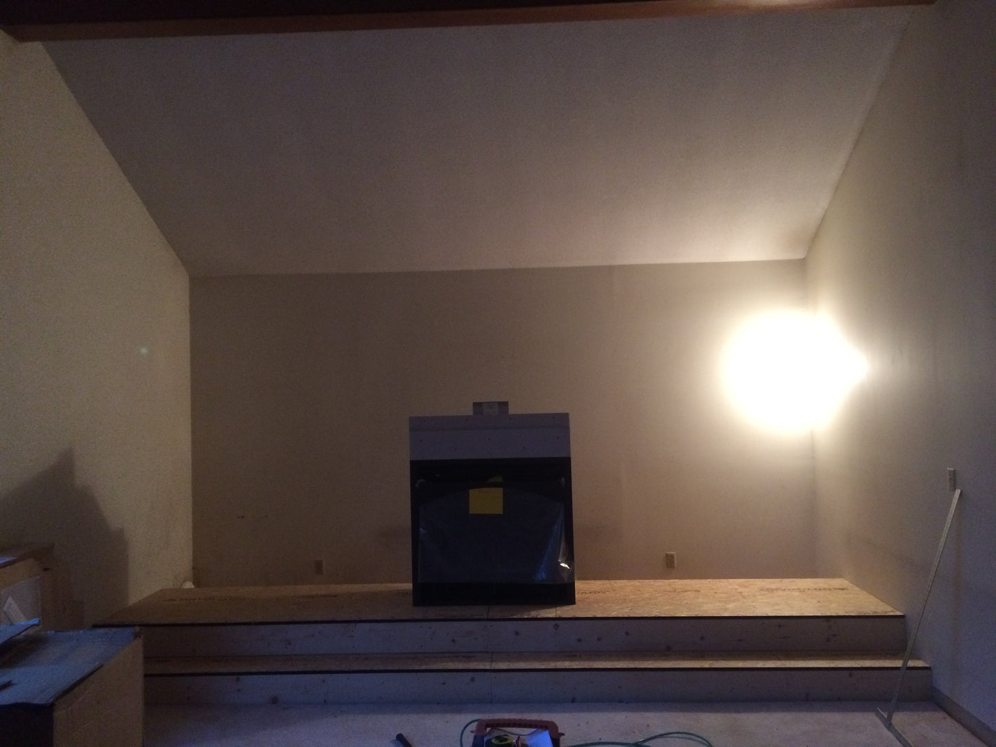 Unfinished room with a fireplace and wooden platform