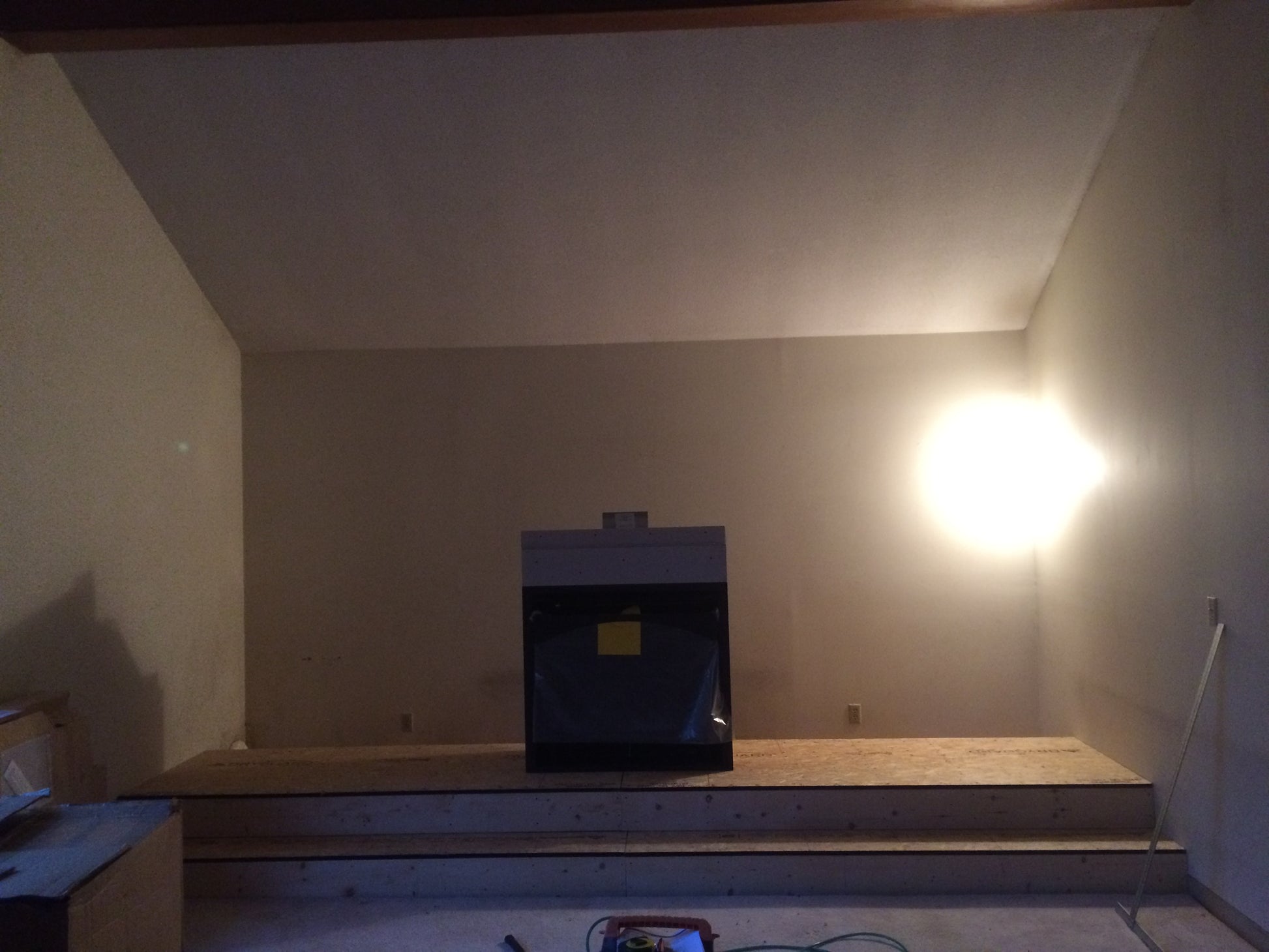 Unfinished room with a fireplace and wooden platform
