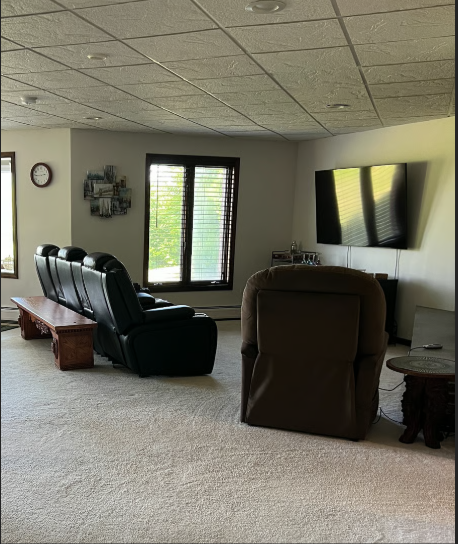 Living room with recliner chairs, a TV, and a window.